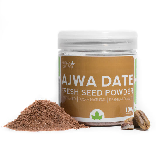 A clear plastic jar labeled 'Ajwa Date Fresh Seed Powder' with a scattering of brown seed powder in front and a single ajwa date to the side.